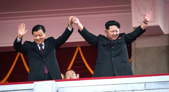 North Korea's leader Kim Jong-Un (R) and Chinese Politburo standing committee member Liu Yunshan (L) wave from a balcony towards participants of a mass military parade at Kim Il-Sung square in Pyongyang on October 10, 2015. (ED JONES/AFP/Getty Images)