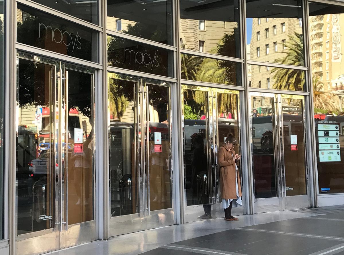 An employee stands outside the closed doors of Macy's department store, during a power cut in San Francisco, Calif., April 21, 2017.<br/>(REUTERS/Alexandria Sage)