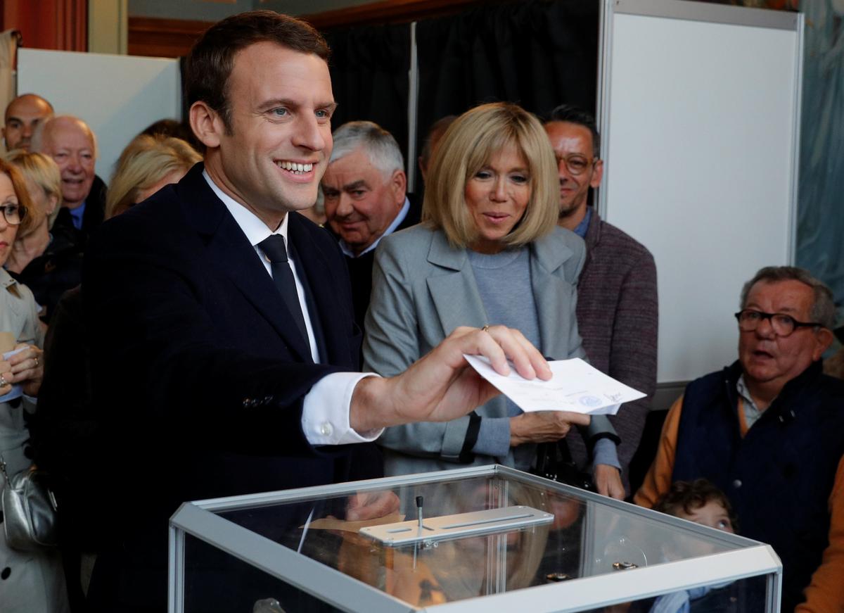 Emmanuel Macron (L), head of the political movement En Marche !, or Onwards !, and candidate for the 2017 French presidential election, casts his ballot in the first round of 2017 French presidential election at a polling station in Le Touquet, northern France on April 23, 2017. (REUTERS/Philippe Wojazer)