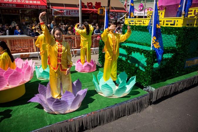 Practitioners demonstrate Falun Gong exercises in a parade in Flushing, New York, on April 23, 2017, to commemorate the 18th anniversary of the April 25th peaceful appeal of 10,000 Falun Gong practitioners in Beijing. (Benjamin Chasteen/The Epoch Times)