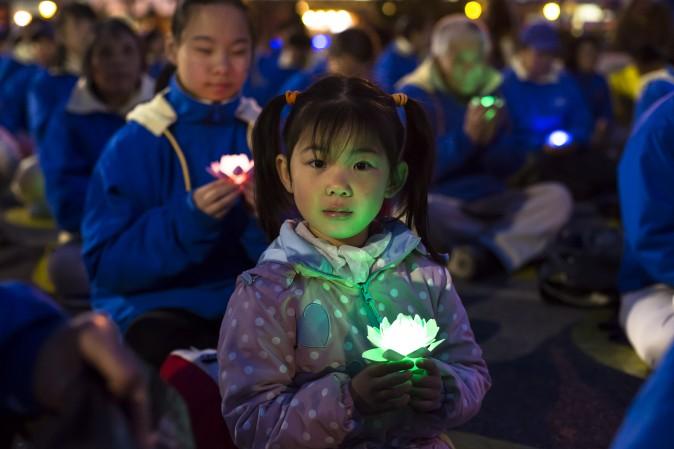 A young Falun Gong practitioner attends a candlelight vigil near the Chinese Consulate in New York on April 23, 2017. (Samira Bouaou/The Epoch Times)