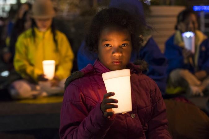 A young Falun Gong practitioner attends a candlelight vigil near the Chinese Consulate in New York on April 23, 2017. (Samira Bouaou/The Epoch Times)
