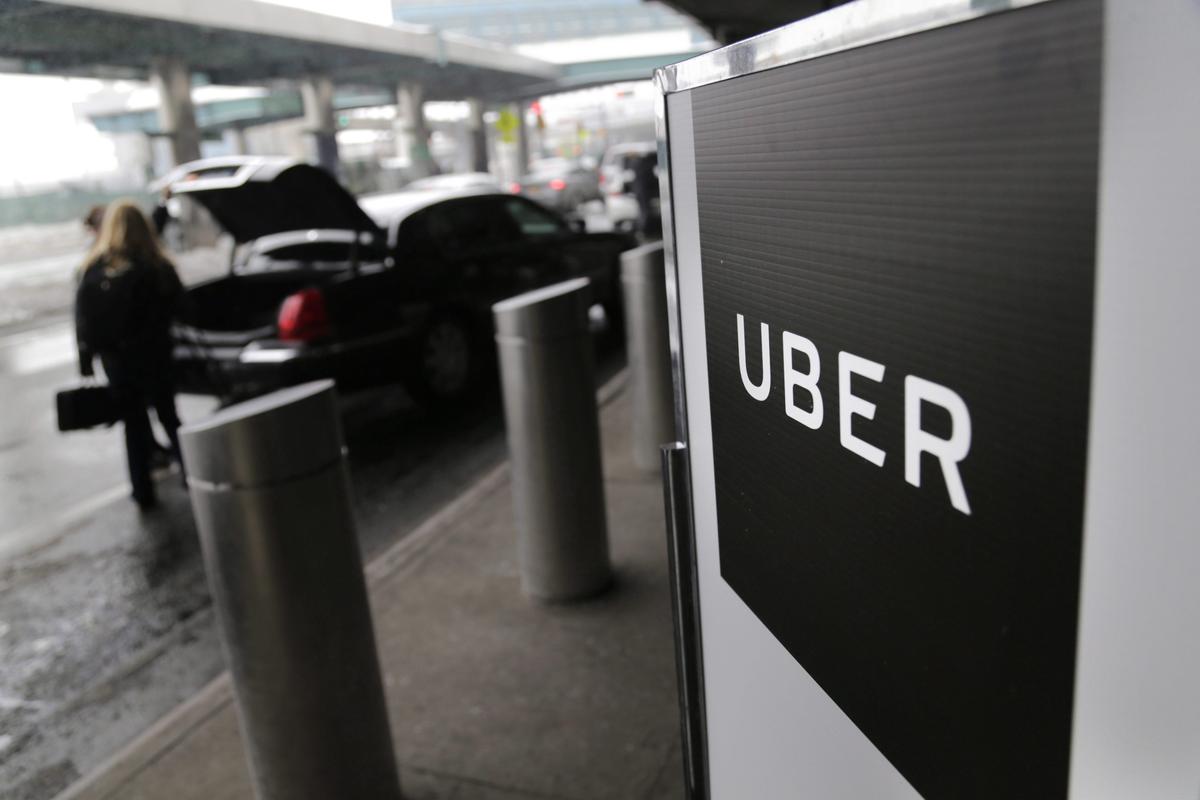 A sign marks a pick-up point for the Uber car service at LaGuardia Airport in New York. (AP Photo/Seth Wenig,)