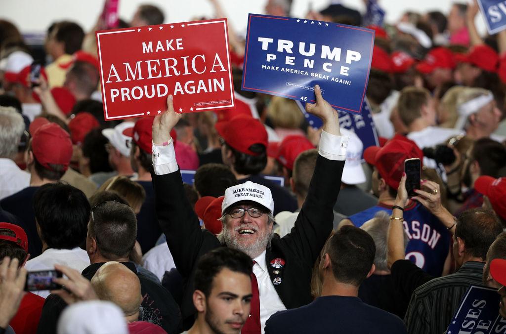 A supporter holds up signs during a "Make America Great Again Rally" at the Pennsylvania Farm Show Complex & Expo Center in Harrisburg, Pa., on April 29, 2017. (Alex Wong/Getty Images)