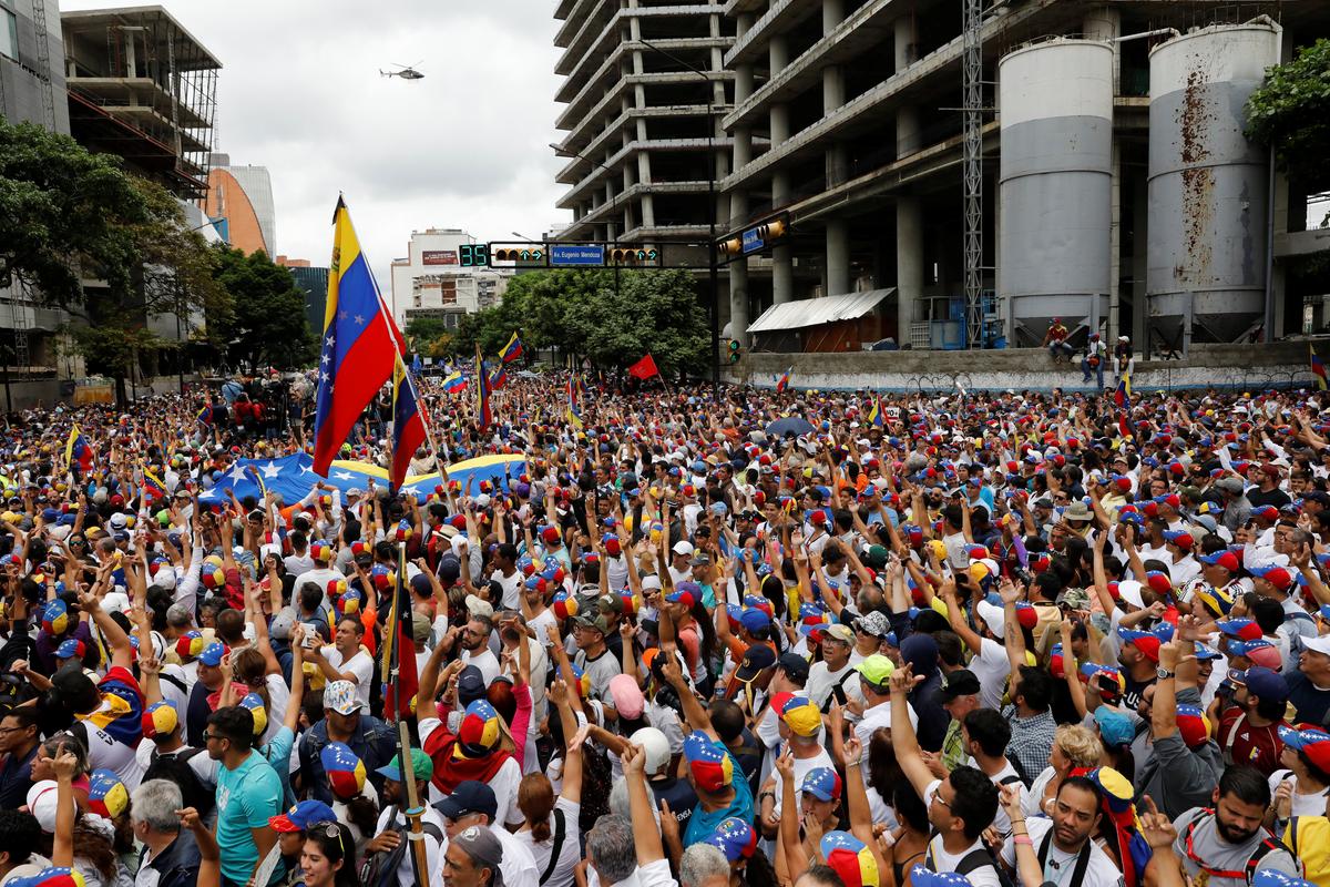 Demonstrators wave as the helicopter passes while rallying against Venezuela's socilist leder Nicolas Maduro in Caracas, Venezuela on May 1, 2017. (REUTERS/Carlos Garcia Rawlins)