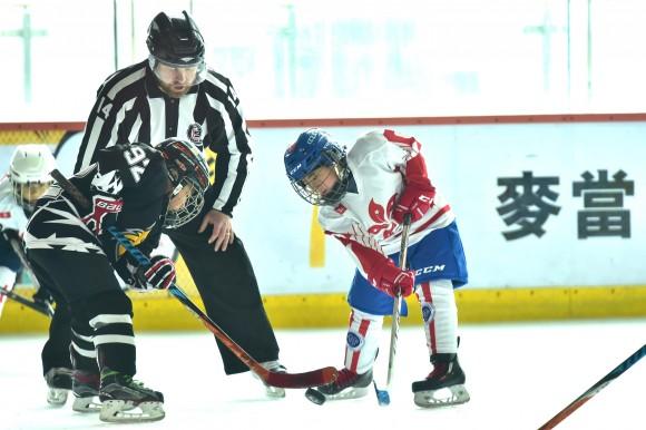 Face-off between Beijing Little Wolves and HKIHA X in their last Pool match of the Mini Squirts A division on Friday April 28. (Bill Cox/Epoch Times)