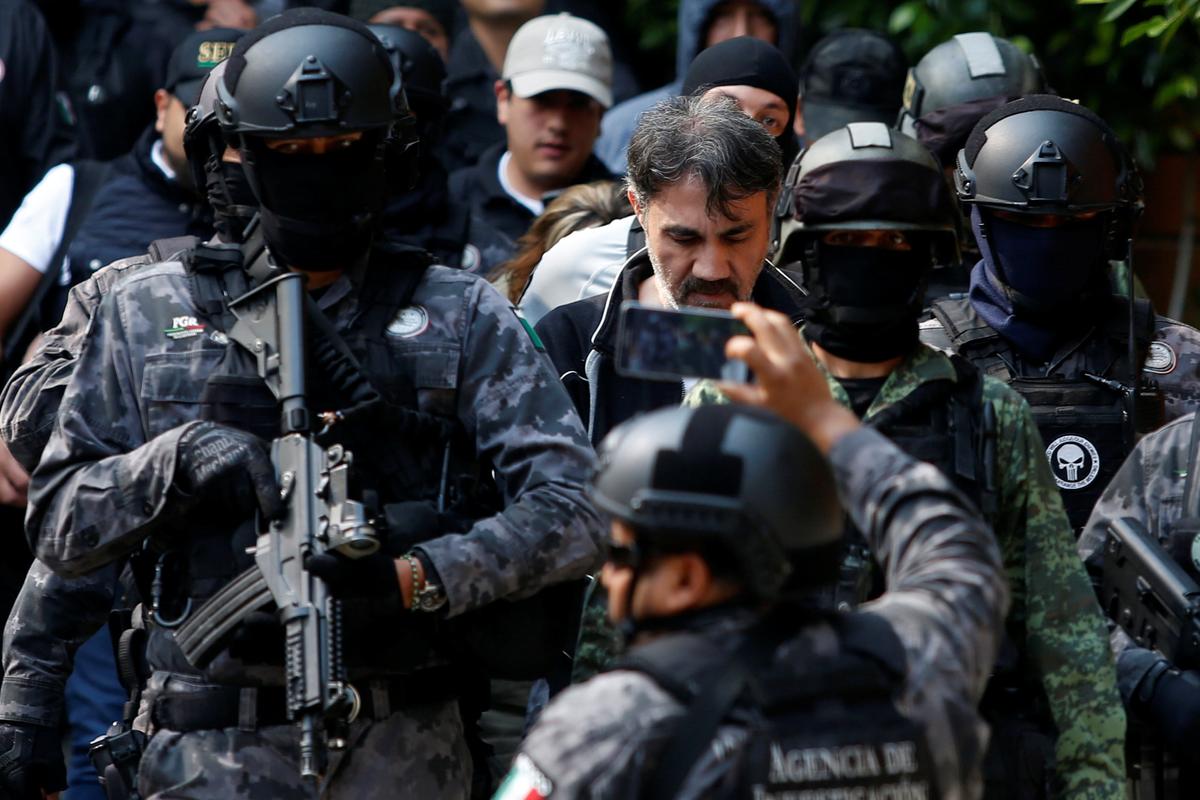 Accused drug kingpin Damaso Lopez (C), nicknamed "The Graduate", is escorted by police officers in Mexico City, Mexico on May 2, 2017. (REUTERS/Carlos Jasso)