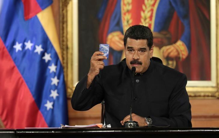 Venezuela's socialist leader Nicolas Maduro holds a copy of the Venezuelan constitution as he speaks during a ceremony at Miraflores Palace in Caracas, Venezuela on May 1, 2017. (Miraflores Palace/Handout via REUTERS)
