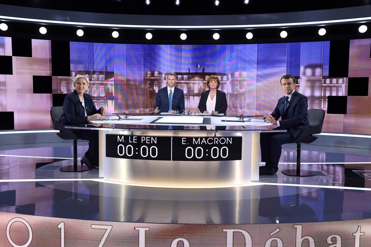 (L-R) French presidential candidate Marine Le Pen, French journalist Christophe Jakubyszyn, French journalist Nathalie Saint-Cricq and French presidential candidate Emmanuel Macron prior to the start of a live broadcast face-to-face debate in television studios of French public national television channel France 2, and French private channel TF1 in La Plaine-Saint-Denis, Paris, France on May 3, 2017. (REUTERS/Eric Feferberg/Pool)