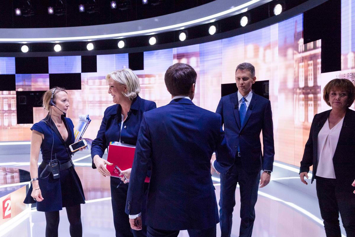 French presidential candidate Marine Le Pen (2ndL), French journalist Christophe Jakubyszyn (Rear 2ndR), French journalist Nathalie Saint-Cricq (R) and French presidential election candidate Emmanuel Macron (C) on the set prior to the start of a live broadcast televised debate in the studios of French public national television channel France 2, and French private channel TF1 in La Plaine-Saint-Denis, near Paris, France on May 3, 2017. (REUTERS/Eric Feferberg/Pool)
