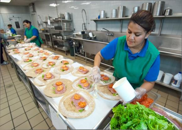 Candy Flores (R) of Arlington Food Services prepares ham and cheese wraps for the National School Lunch Program in the kitchen at Washington-Lee High School in Arlington, Va., Oct. 19, 2011. (U.S. Department of Agriculture)