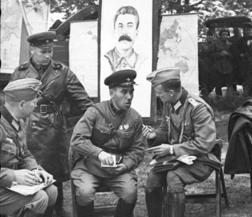 Soviet and German officers socializing during a victory celebration in Poland on Sept. 22, 1939. A poster of Stalin hangs behind them (Bundesarchiv, Bild/CC-BY-SA 3.0)