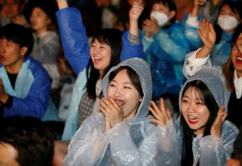 Supporters of presidential candidate Moon Jae-in react as they watch a television broadcast of the presidential election exit polls result in Seoul, South Korea on May 9, 2017. (REUTERS/Kim Kyung-Hoon)