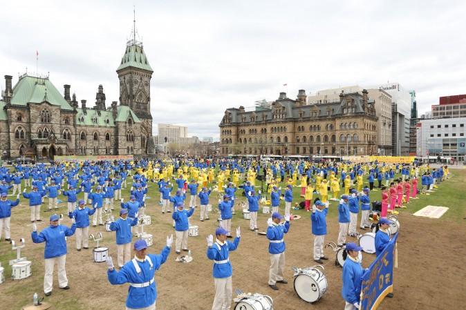 Falun Gong practitioners perform the slow-moving Falun Gong exercises during a celebration on Parliament Hill marking the 25th anniversary of the practice's introduction to the public, May 9, 2017. (Evan Ning/Epoch Times)