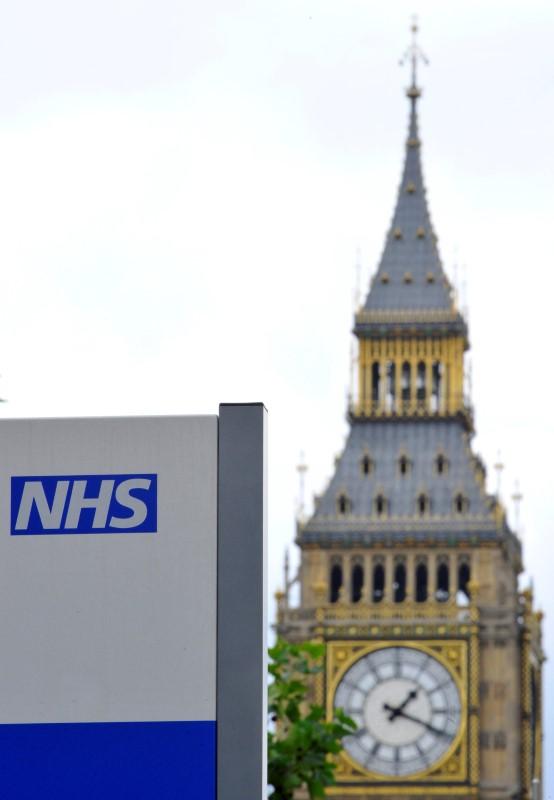 A National Health Service (NHS) sign is seen in the grounds of St Thomas' Hospital, in front of the Houses of Parliament in London on June 7, 2011. (REUTERS/Toby Melville)