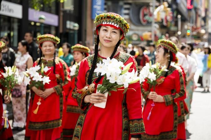 Falun Dafa practitioners wearing ethnic Chinese clothes, march in a parade along 42nd Street in New York for World Falun Dafa Day on May 12, 2017. Mr. Li Hongzhi, the founder of Falun Dafa, gave his first lecture 25 years ago on May 13 in his native city of Changchun in China. Today, Falun Dafa is practiced by tens of millions in over 70 countries. (Samira Bouaou/The Epoch Times)