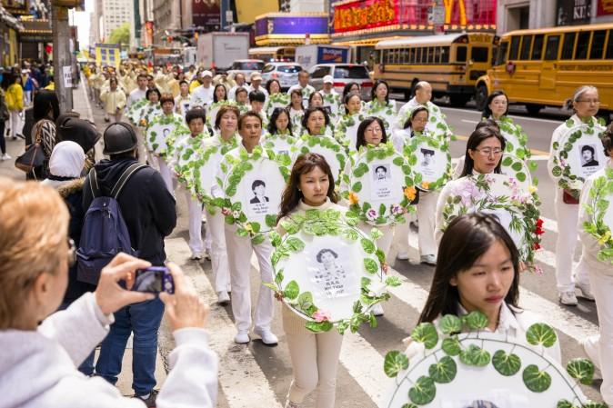 Falun Gong practitioners hold wreaths with photos of people who were killed inside China for their beliefs during the World Falun Dafa Day parade in New York on May 12, 2017. (Samira Bouaou/The Epoch Times)