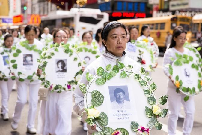 Falun Gong practitioners hold wreaths with photos of people who were killed inside China for their beliefs during the World Falun Dafa Day parade in New York on May 12, 2017. (Samira Bouaou/The Epoch Times)
