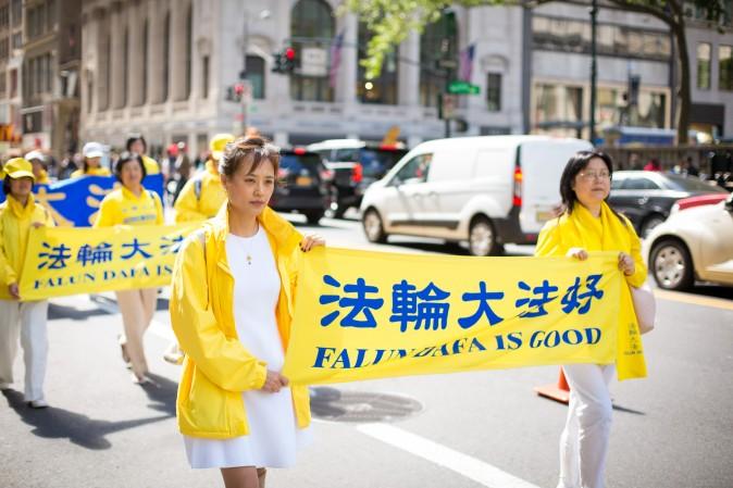 Thousands of Falun Gong practitioners march in a parade along 42nd Street in New York for World Falun Dafa Day on May 12, 2017. (Benjamin Chasteen/The Epoch Times)
