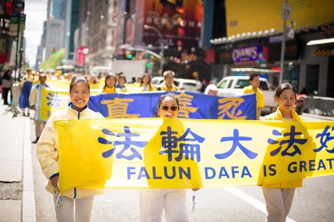 Thousands of Falun Gong practitioners from around the world march in a parade along 42nd Street in New York for World Falun Dafa Day on May 12, 2017. (Benjamin Chasteen/The Epoch Times)