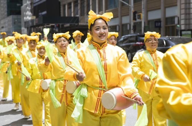 Thousands of Falun Gong practitioners march in a parade along 42nd Street in New York for World Falun Dafa Day on May 12, 2017. (Gary Wong/The Epoch Times)