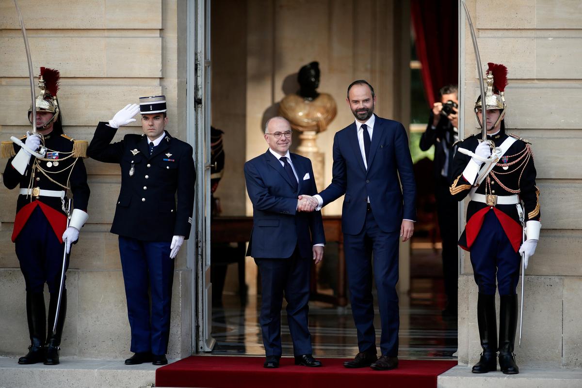 Newly-appointed French Prime Minister Edouard Philippe (R) is greeted by his predecessor Bernard Cazeneuve (L) during a handover ceremony at the Hotel Matignon, in Paris, France on May 15, 2017. ( REUTERS/Benoit Tessier)