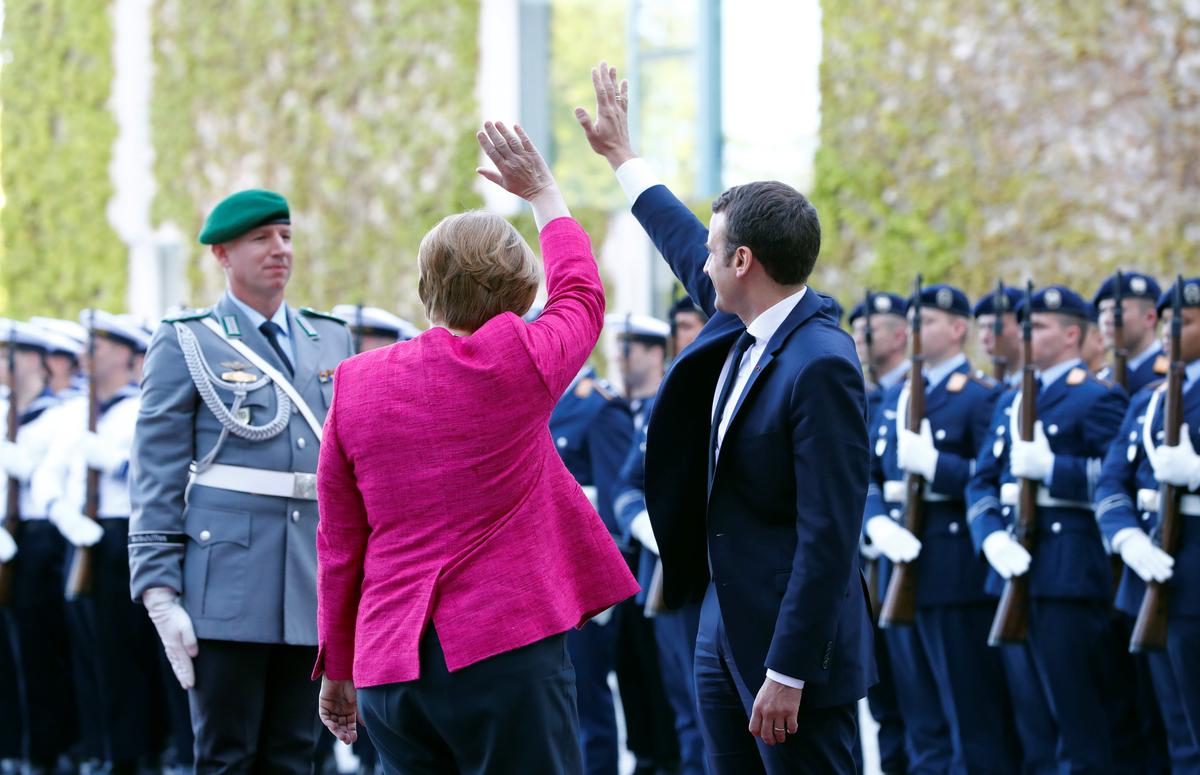 German Chancellor Angela Merkel and French President Emmanuel Macron greet at a ceremony at the Chancellery in Berlin, Germany on May 15, 2017. (REUTERS/Fabrizio Bensch)