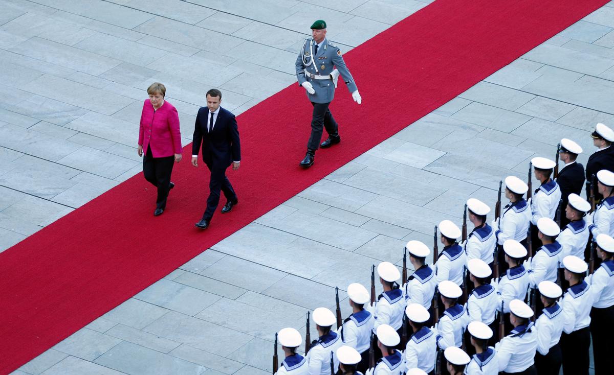 German Chancellor Angela Merkel and French President Emmanuel Macron arrive at a ceremony at the Chancellery in Berlin, Germany on May 15, 2017. (REUTERS/Hannibal Hanschke)