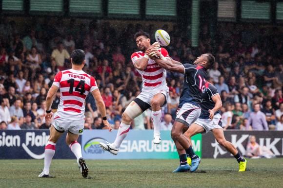The Japanese winger and try scorer Amanaki Lotoahea jumps for the ball under pressure from Hong Kong centre Lex Kaleca. (Dan Marchant)