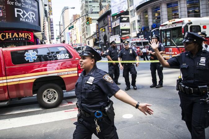 NYPD officers gesture to the crowd to step back after a vehicle struck pedestrians on the sidewalk in Times Square, New York, on May 18, 2017. (Samira Bouaou/The Epoch Times)