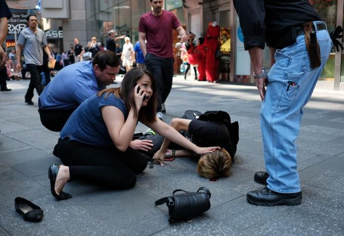 People attend to an injured man after a car plunged into a crowd in Times Square in New York on May 18, 2017. (JEWEL SAMAD/AFP/Getty Images)