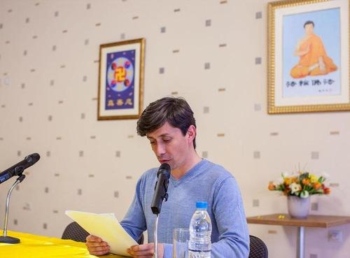 A Falun Dafa practitioner reading his experience sharing paper at the conference. (Minghui.org)