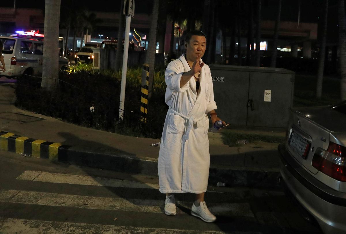 A tourist wearing a bathrobe gestures after he was evacuated from the Resorts World Manila after gunshots and explosions were heard in Pasay City, Metro Manila, Philippines on June 2, 2017. (REUTERS/Erik De Castro)