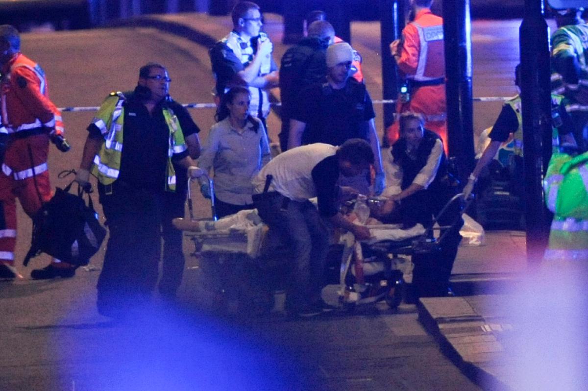 Police officers and members of the emergency services attend to a person injured in an apparent terror attack on London Bridge in central London on June 3, 2017. (Daniel Sorabji/AFP/Getty Images)