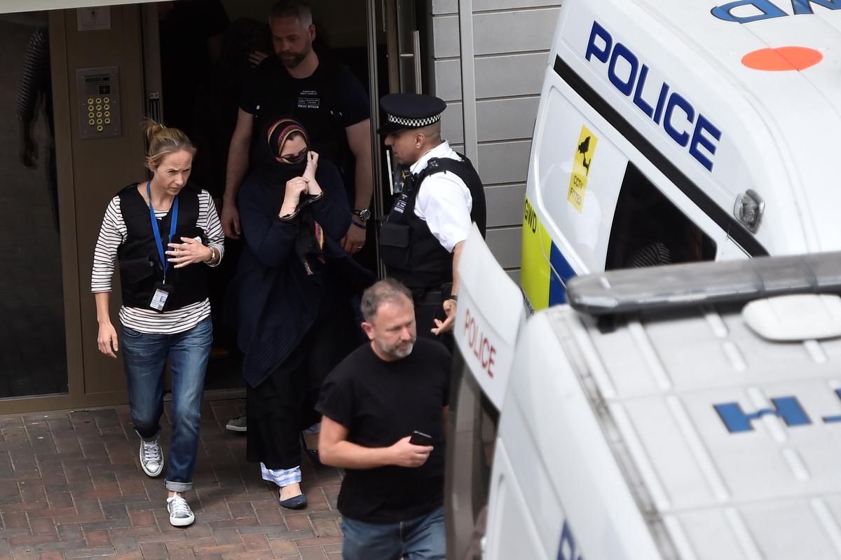Police officers escort a woman to a police van after raiding a block of flats in Barking, east London, Britain on June 4, 2017. (REUTERS/Hannah McKay)
