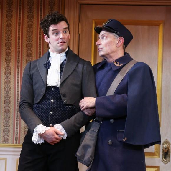 (L–R) Ivan Alexandreyevich Hlestekov (Michael Urie) who is assumed to be government official sent to spy on the town, and the Postmaster (Arnie Burton), in "The Government Inspector." (Carol Rosegg)