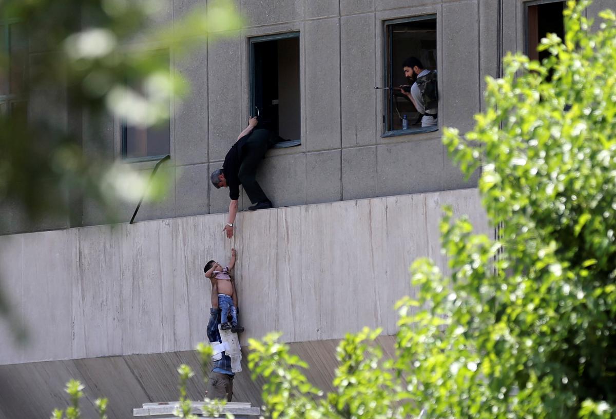 A boy is evacuated during an attack on the Iranian parliament in central Tehran, Iran on June 7, 2017. (Omid Vahabzadeh/TIMA via REUTERS)