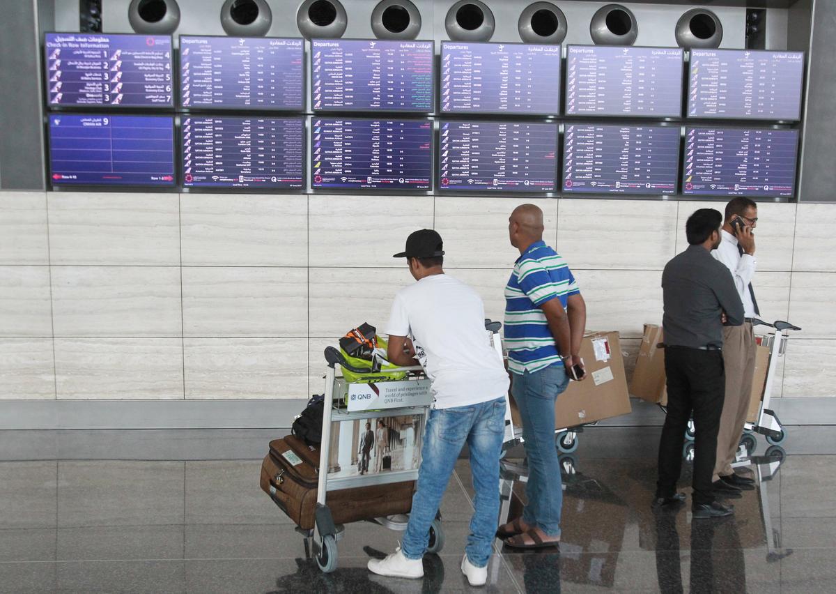 Passengers look at flight details at Hamad International Airport in Doha, Qatar on June 7, 2017. (REUTERS/Naseem Zeitoon)