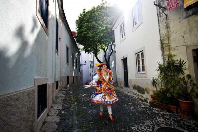 A woman dressed in a traditional costume, walks down a street in the Lisbon neighborhood of Alfama, before attending the Santo Antonio de Lisboa's Parade on Avenida da Liberdade, on June 12. (PATRICIA DE MELO MOREIRA/AFP/Getty Images)