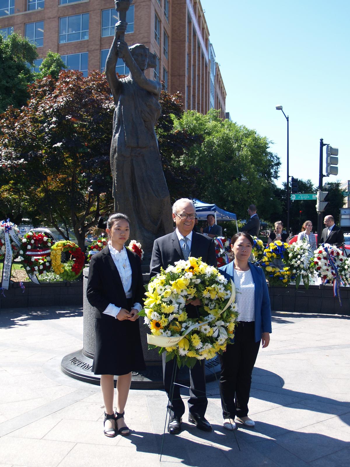 Xu Xinyang (L), Alan Adler, and Chi Lihua present a wreath remembering the victims of communism at the tenth annual Truman-Reagan Medal of Freedom and Roll Call of Nations Ceremony, on June 9 in Washington, D.C. Adler is the executive director of Friends of Falun Gong, Xu and Li are practitioners of Falun Gong who suffered persecution in China for their beliefs. (Kitty Wang, NTDTV)