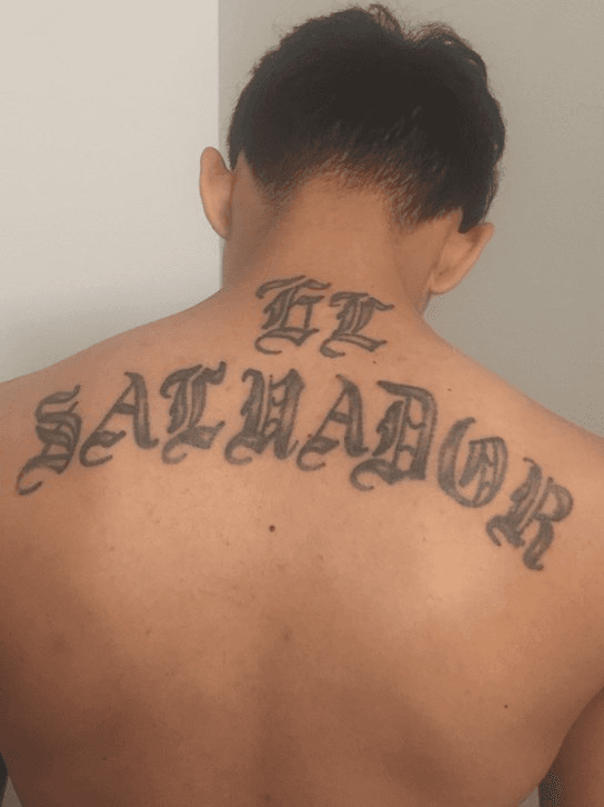 An arrested gang member with a tattoo saying "El Salvador," in New York. (Courtesy of ICE)
