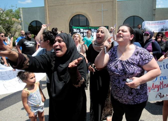 A group of women react as they talk about family members seized on Sunday by Immigration and Customs Enforcement agents in Southfield, MI, on June 12, 2017. (Rebecca Cook/Reuters)