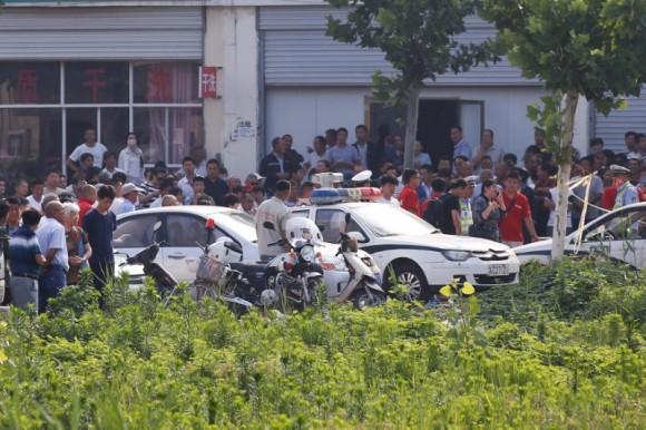 Onlookers and security personnel gather near the scene of an explosion at a kindergarten in Fengxian County in Jiangsu Province, China June 16, 2017. (Reuters/Aly Song)