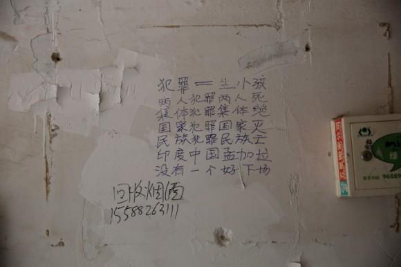 Chinese characters reading "crime equals to giving birth, two people crime, two people die, group crime, group die, country crimes, country dies, ethnic crimes, ethnic dies, India China Bangladesh, none will have a good end" are seen on a wall inside a residential building next to the scene of an explosion inside a kindergarten in Fengxian County of Xuzhou in Jiangsu Province, China June 16, 2017. (Reuters/Aly Song)