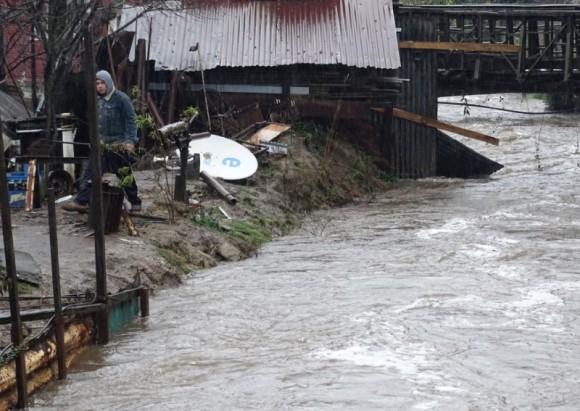 A man walks beside a flooded street due to torrential rains causing a river to overflow, in Curanilahue city, south of Chile, June 16, 2017. (Reuters/Manuel Araneda)