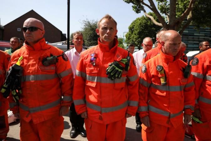 Members of the emergency services attend a minute's silence for the victims of the Grenfell Tower fire near the site of the blaze in North Kensington, London, Britain, June 19, 2017. (Marko Djurica/Reuters)