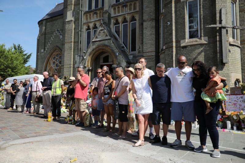 People attend a minute's silence for the victims of the Grenfell Tower fire near the site of the blaze in North Kensington, London, Britain on June 19, 2017. (REUTERS/Marko Djurica)