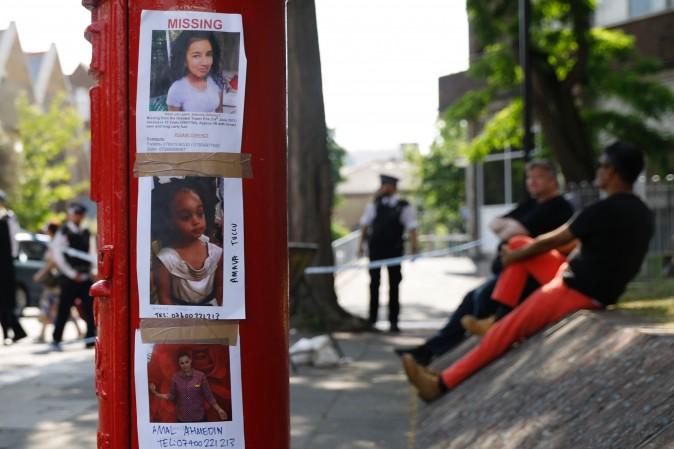 The pictures of people missing after the Grenfell Tower block fire, (top-bottom) Jessica Urbano, Amava Tuccu and Amal Ahmedin, are seen taped to a post box near the scene in North Kensington, west London, on June 18, 2017. (Tolga Akmen/AFP/Getty Images)