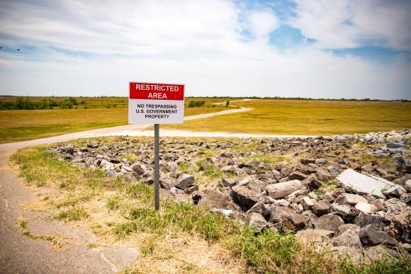 A sign next to a border patrol road that cuts through the levee behind Granjeno, Texas, warns that the area is restricted. (Benjamin Chasteen/The Epoch Times)