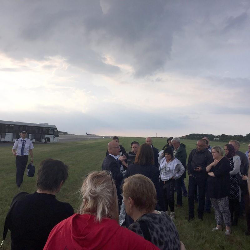 Passengers stand on the grass next to a runway after being evacuated from a Scandinavian Airlines Systems plane which was forced to make an emergency landing shortly after takeoff due to smoke in the cabin, at Gdansk airport, Poland June 20, 2017, in this picture obtained from social media. (Sergey Shtypuliak via REUTERS)
